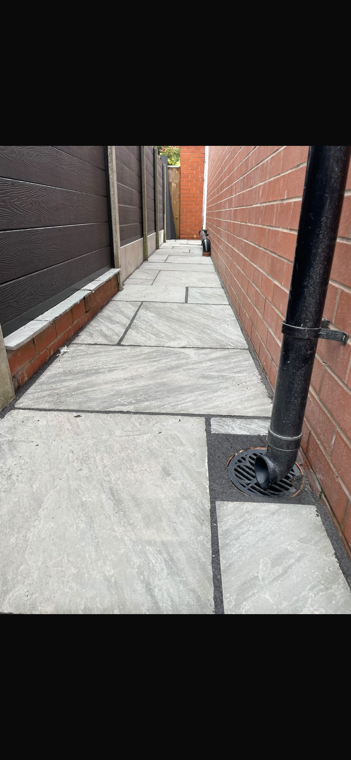 Grey sandstone side path with new drainage channel