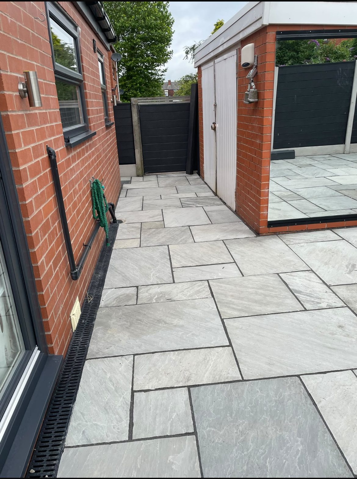 Silver grey natural stone patio with feature wall and garden room